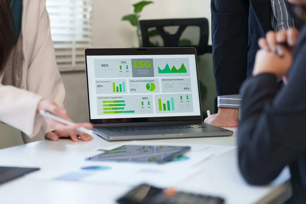 bankers talking about sustainability with graphics on macbook