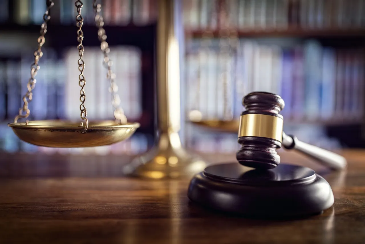 balance et hammer from a judge on a wooden table, reference to justice and laws